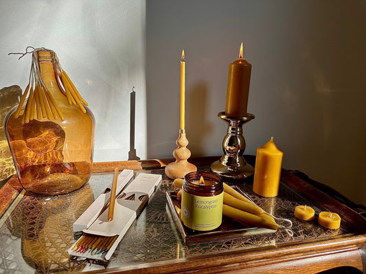 Reine Bienenwachskerzen und ätherische Duftkerzen auf Tisch – reinigen die Luft, schenken Wohlbefinden, Licht und Entspannung im Zuhause.