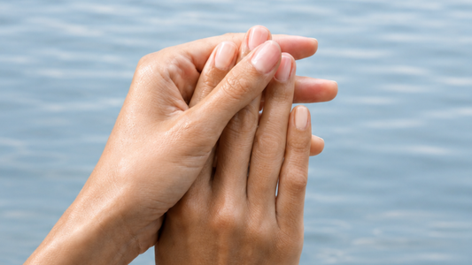 Gepflegte Hände mit Nagelöl, das in die Nägel und Nagelhaut einmassiert wird, für geschmeidige und gesunde Fingernägel.