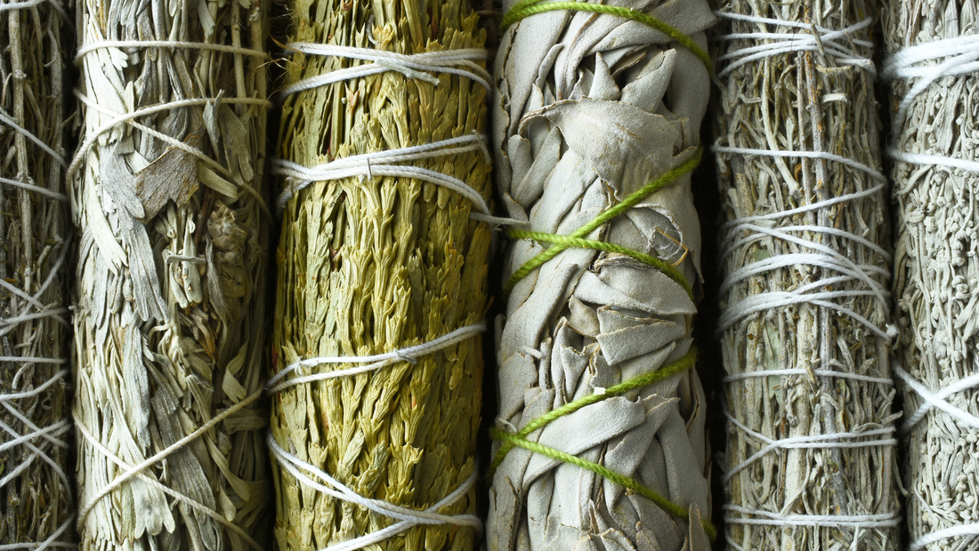 Verscheidene Salbei-Bündel, mit Lavendel, Eukalyptus, Rosmarin nebeneinander.