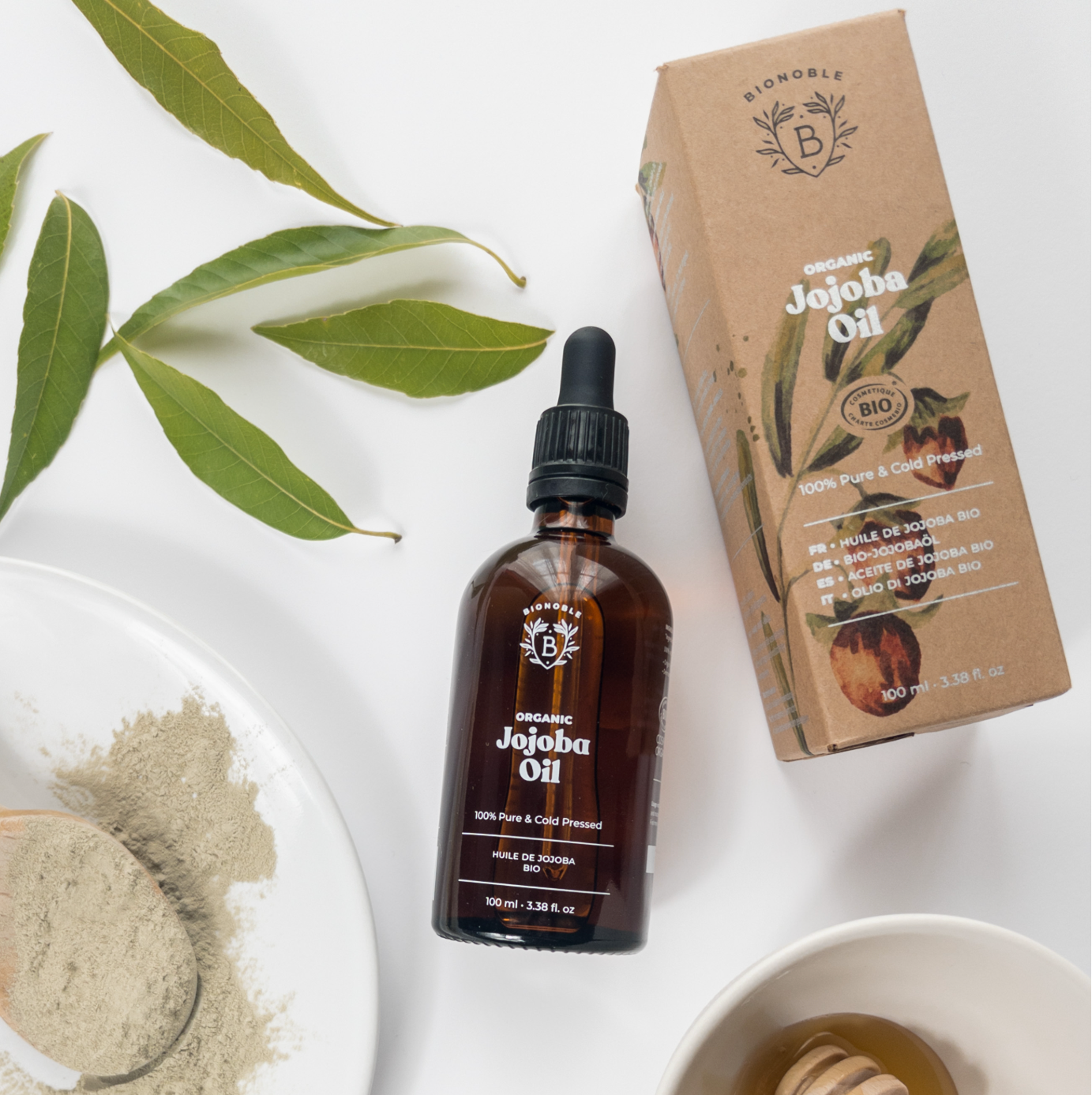 Jojoba Öl in Braunglas Flasche und Papierkarton. 100 % biologisches Haut- und Haarpflegeöl aus kontrolliert ökologischem Anbau