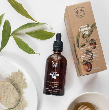 Jojoba Öl in Braunglas Flasche und Papierkarton. 100 % biologisches Haut- und Haarpflegeöl aus kontrolliert ökologischem Anbau
