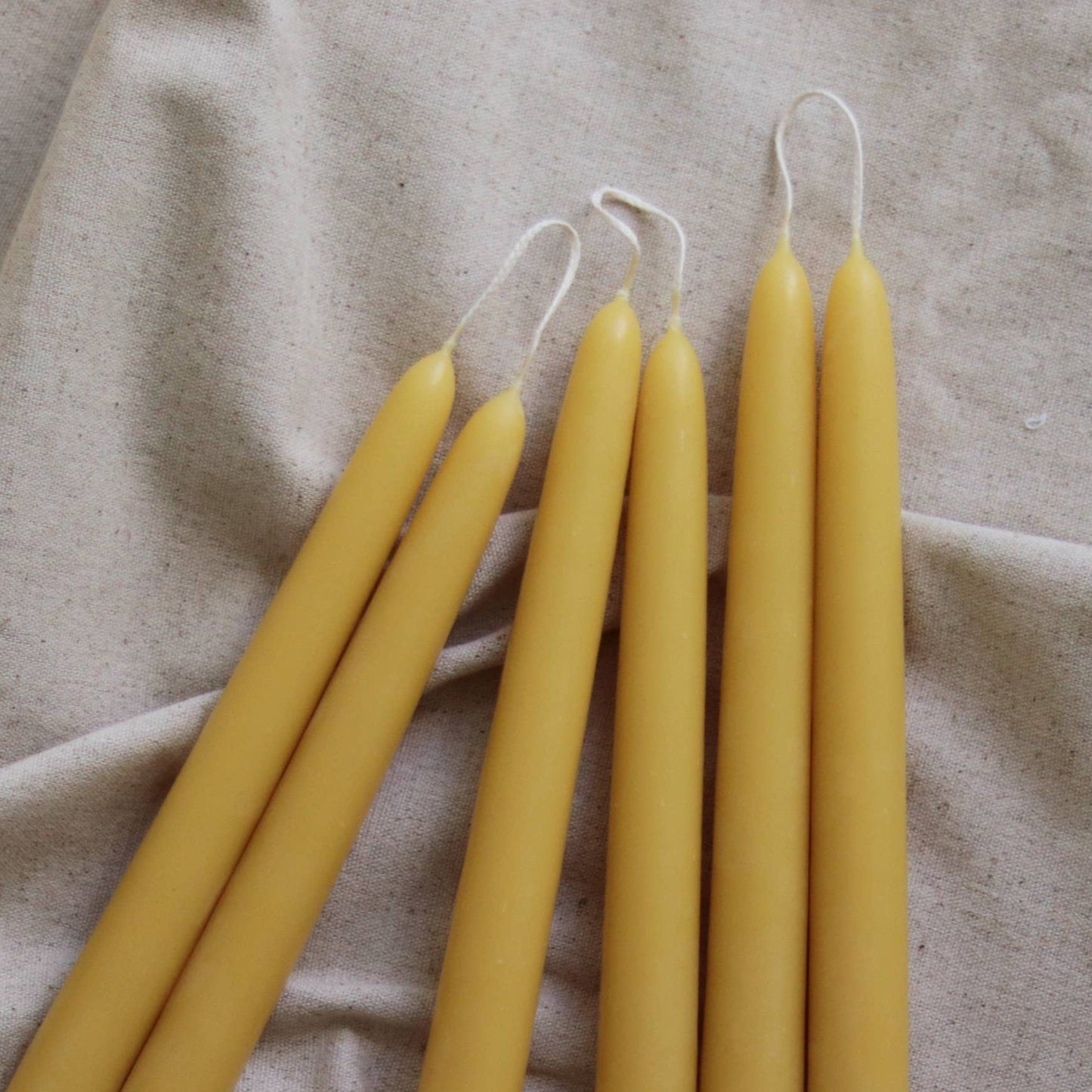 Zwei Bienenwachs-Dinnerkerzen brennen mit warmem, ruhigem Licht und schaffen eine gemütliche Atmosphäre