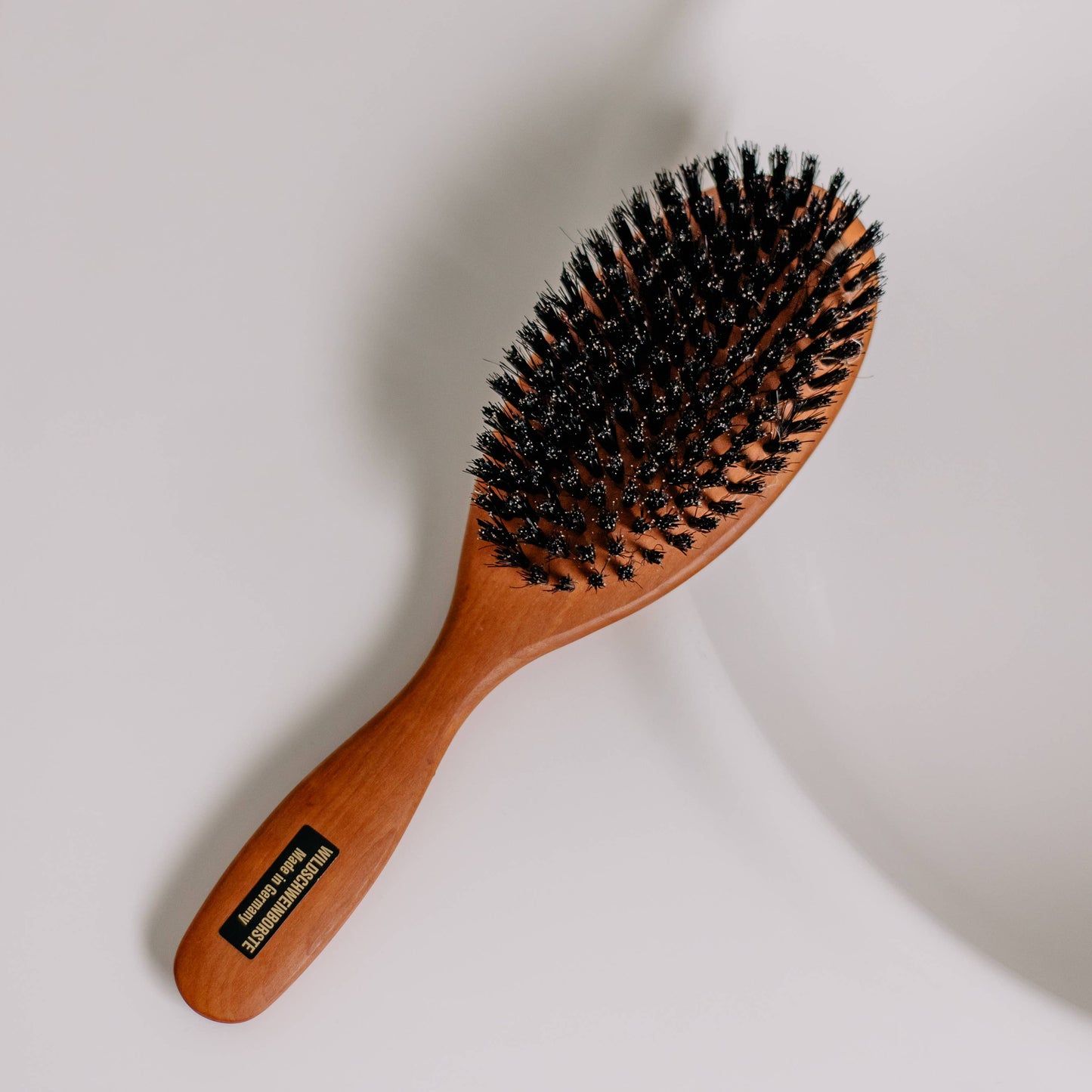 Haarbürste mit dichten Wildschweinborsten – sanftes Bürsten, unterstützt Durchblutung, natürliche Öle und ausbalanciertes Haargefühl.