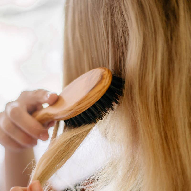 Nachhaltige Haarbürste aus massivem Olivenholz – traditionelles Handwerk, natürliche Pflege, elastisches, gesundes Haargefühl.