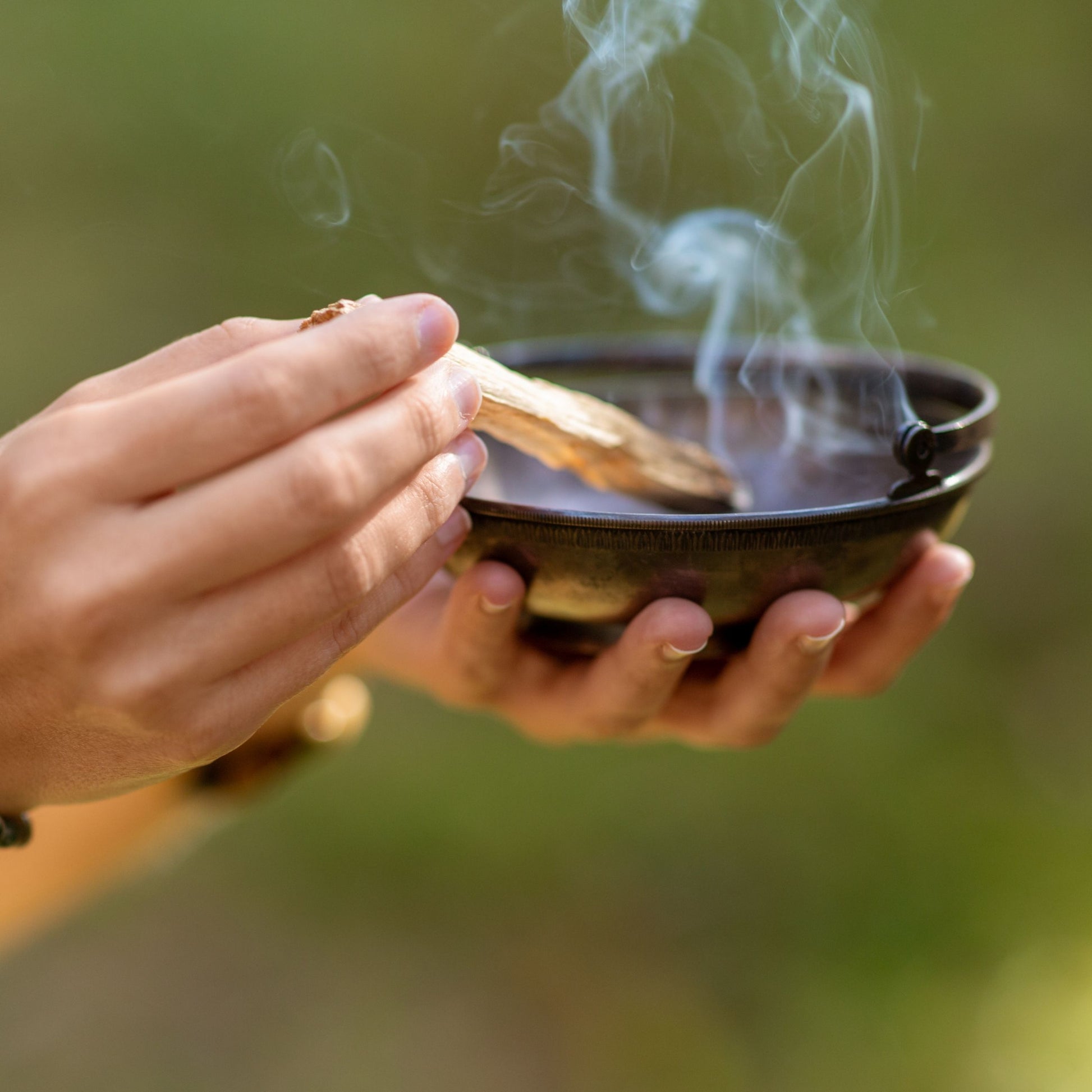 Palo Santo Stäbchen im Einsatz bei einem Reinigungsritual, Rauch verbreitet beruhigende und klärende Energie.