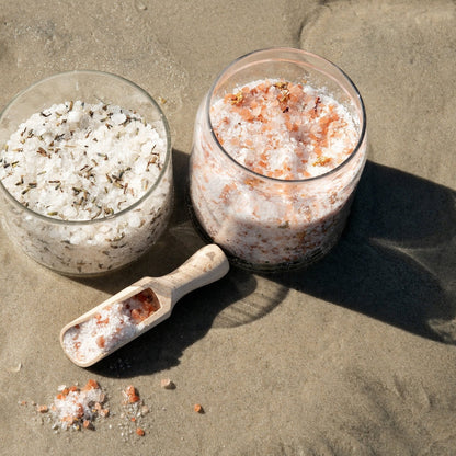 Zwei Badesalze nebeneinander am Strand – Rosen & Himalaya Mineralsalz und Eukalyptus-Lavendelblüten Badesalz, naturrein, pflegend und entspannend für Körper und Sinne