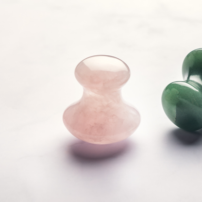 Rosenquarz Gua Sha Pilz als Beauty-Tool für die Augenmassage in natürlicher Badezimmer-Atmosphäre