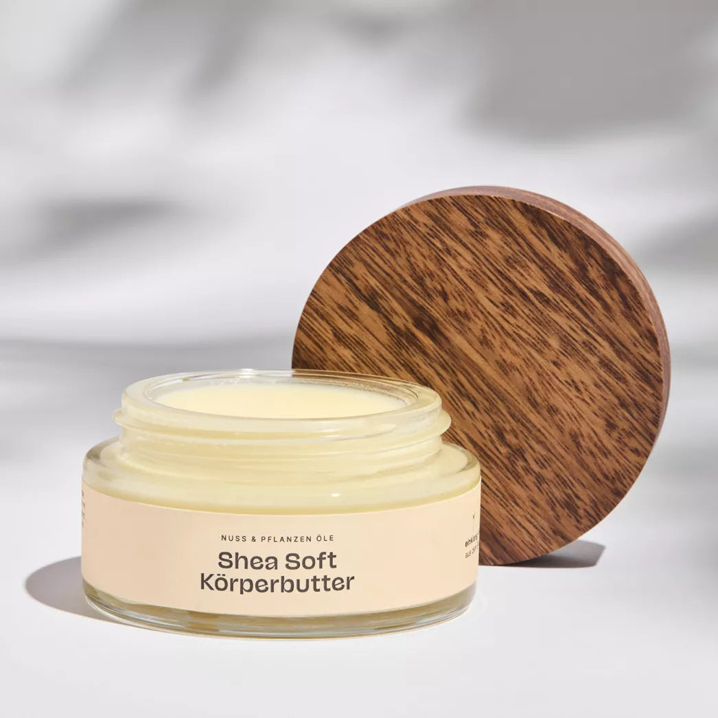 Geöffneter Glastiegel der Shea-Soft Bio Körperbutter, zeigt cremige, naturreine Textur für reichhaltige Pflege.