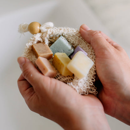 Sisal-Seifensäckchen in der Hand, sanftes Peeling während der Hautpflege-Routine unter der Dusche, entfernt abgestorbene Hautzellen und fördert weiche, glatte Haut.