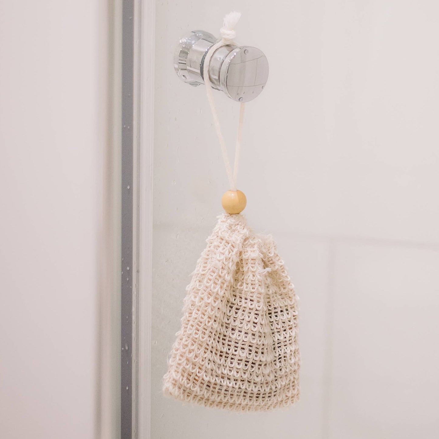 Nahaufnahme eines Sisal-Seifensäckchens mit Seifenstück, kombiniert sanftes Peeling mit hygienischer Aufbewahrung, perfekt für Dusche, Bad oder Reise.