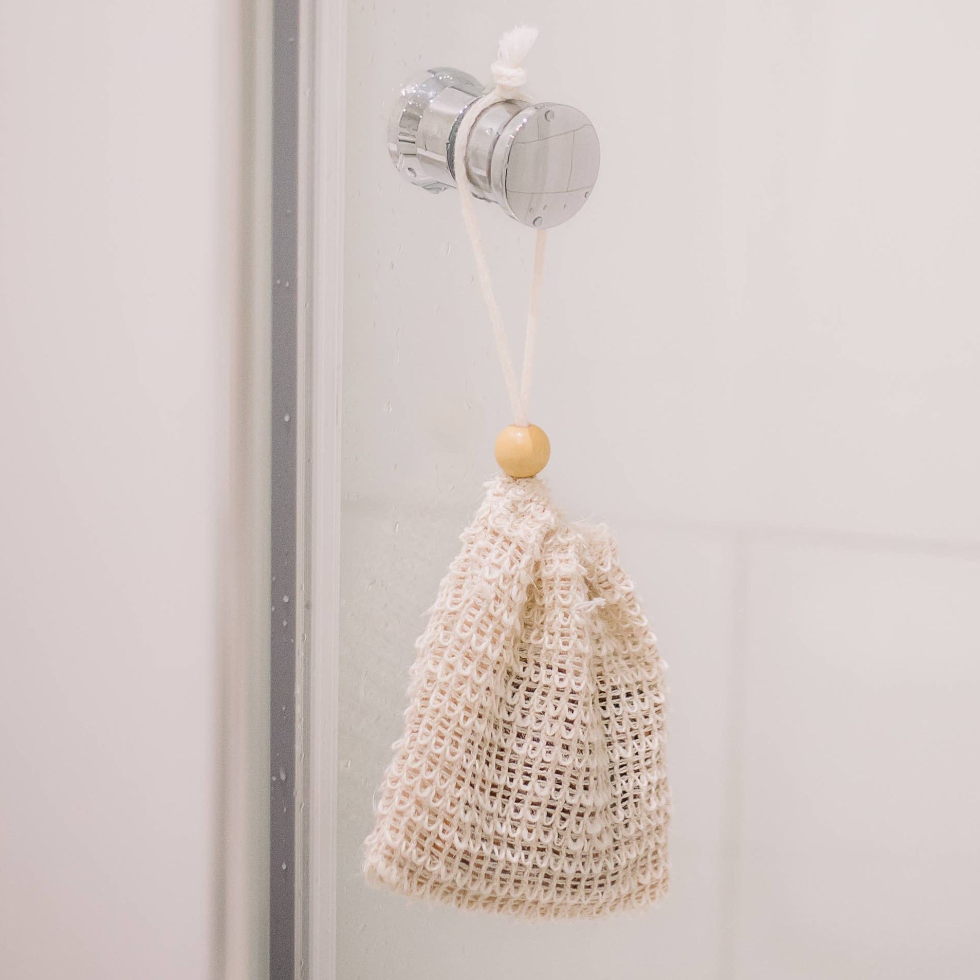Nahaufnahme eines Sisal-Seifensäckchens mit Seifenstück, kombiniert sanftes Peeling mit hygienischer Aufbewahrung, perfekt für Dusche, Bad oder Reise.