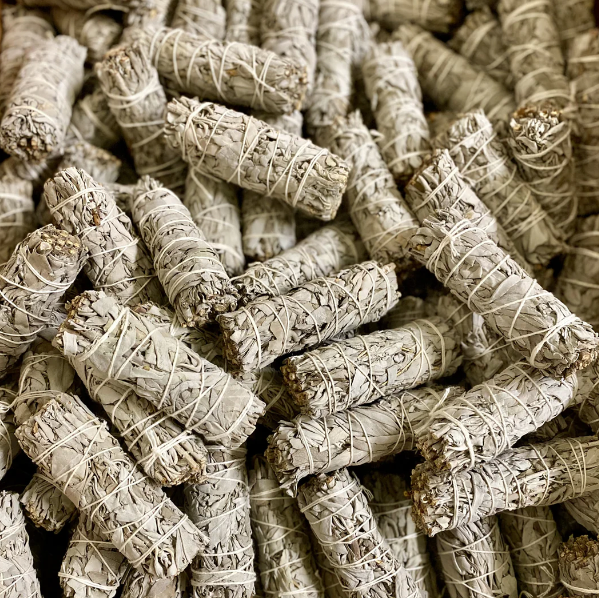 Detail der traditionellen Bindung eines naturbelassenen weißen Salbei Bündels mit Baumwollfaden.