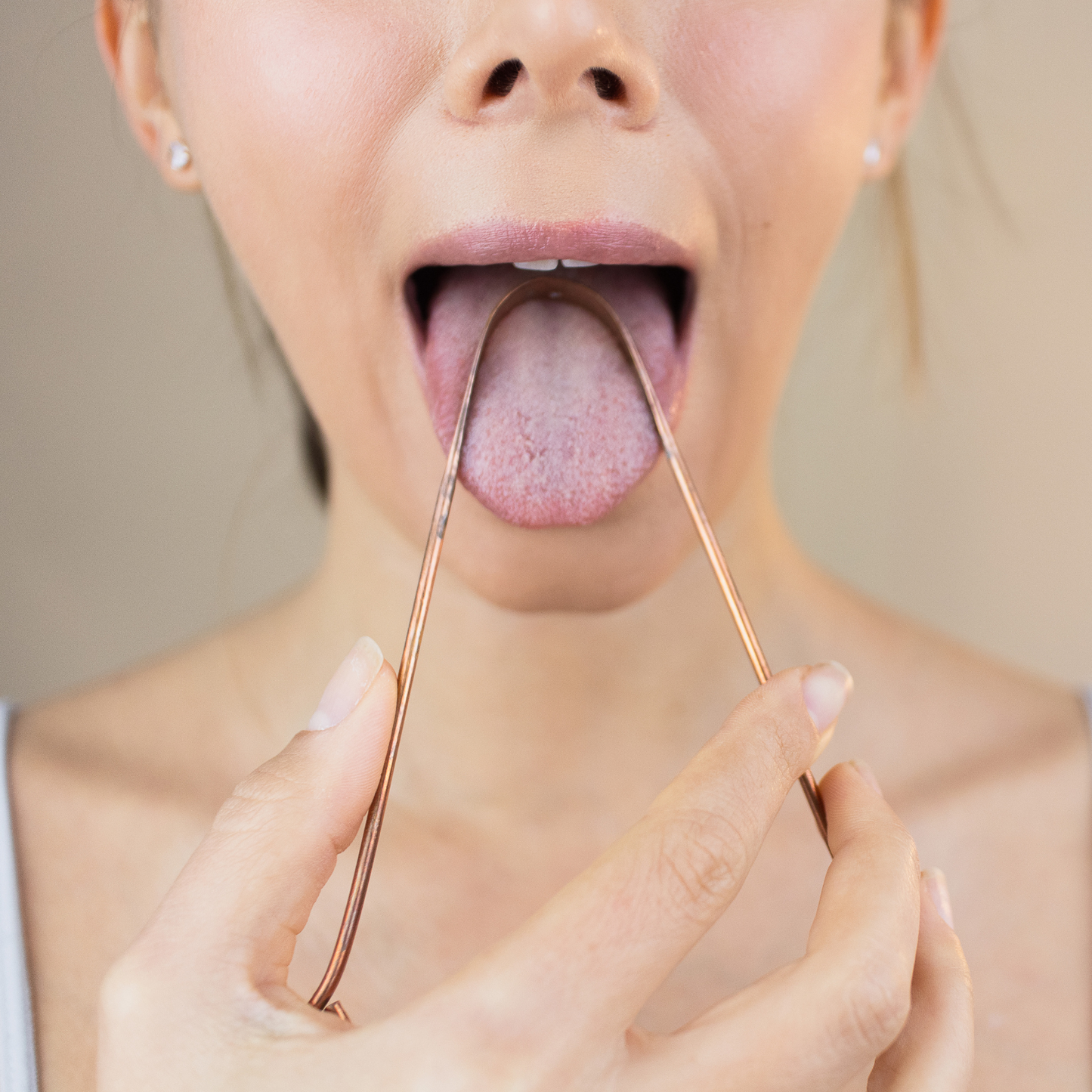 Anwendung des Kupfer Zungenschabers zur ayurvedischen Mundpflege am Morgen